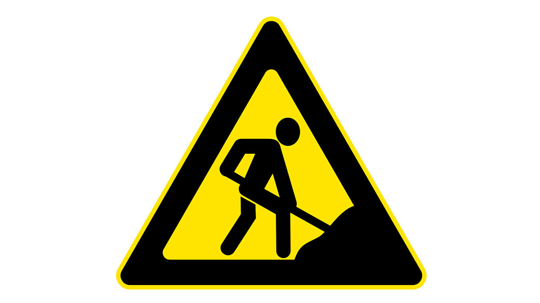 Gul och svart varningstriangel med en person som gräver.